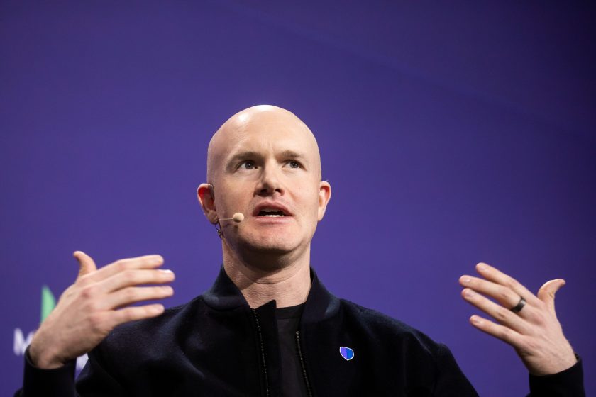 El director ejecutivo de Coinbase, Brian Armstrong, frente a un fondo morado y con una camisa negra.