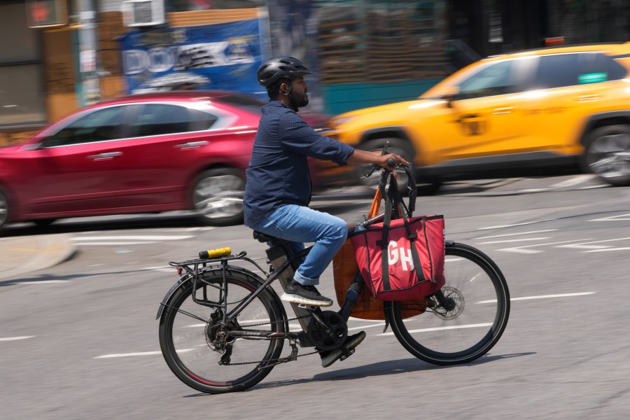 ARCHIVO - Un repartidor anda en una bicicleta motorizada, 25 de julio de 2023, en Nueva York.  El lunes 13 de noviembre, funcionarios de la ciudad de Nueva York dijeron que los minoristas y las empresas de entrega de alimentos deben hacer más para detener la proliferación de baterías inseguras para bicicletas y scooters eléctricos después de que un incendio atribuido a la batería de iones de litio de un scooter eléctrico matara a tres personas más de el fin de semana.  (Foto AP/Seth Wenig, archivo)