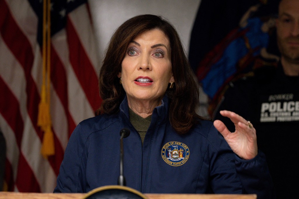 La gobernadora de Nueva York, Kathy Hochul, hablando desde un podio con una bandera detrás de ella después de un incidente en el cruce fronterizo del Puente Arcoíris en las Cataratas del Niágara.