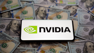 Logotipo de Nvidia visto en un teléfono inteligente colocado sobre un montón de billetes de dólares estadounidenses.  Concepto.  Enfoque selectivo.  Acciones para comprar como Nvidia