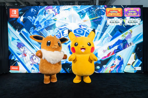 En esta foto proporcionada por Nintendo of America, Pikachu y Eevee están frente a una pancarta en PAX East con el tema El tesoro escondido del Área Cero Parte 2: El DLC Indigo Disk para Pokémon Escarlata o Pokémon Violeta.