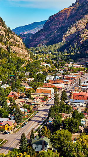 Foto aérea de una calle de Ouray, Colorado, con montañas asomando.