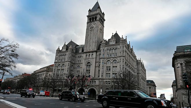 Una caravana acelera por la Avenida Pennsylvania pasando por lo que alguna vez fue el Hotel International Trump en Washington, DC, el 24 de enero de 2019.