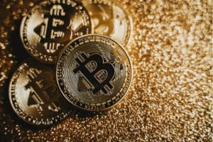 tres bitcoins dorados sobre arena dorada