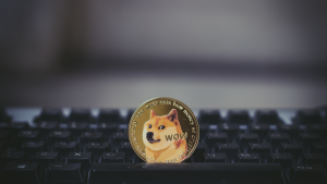 Una moneda Golden Dogecoin en el teclado, monedas Meme para vender