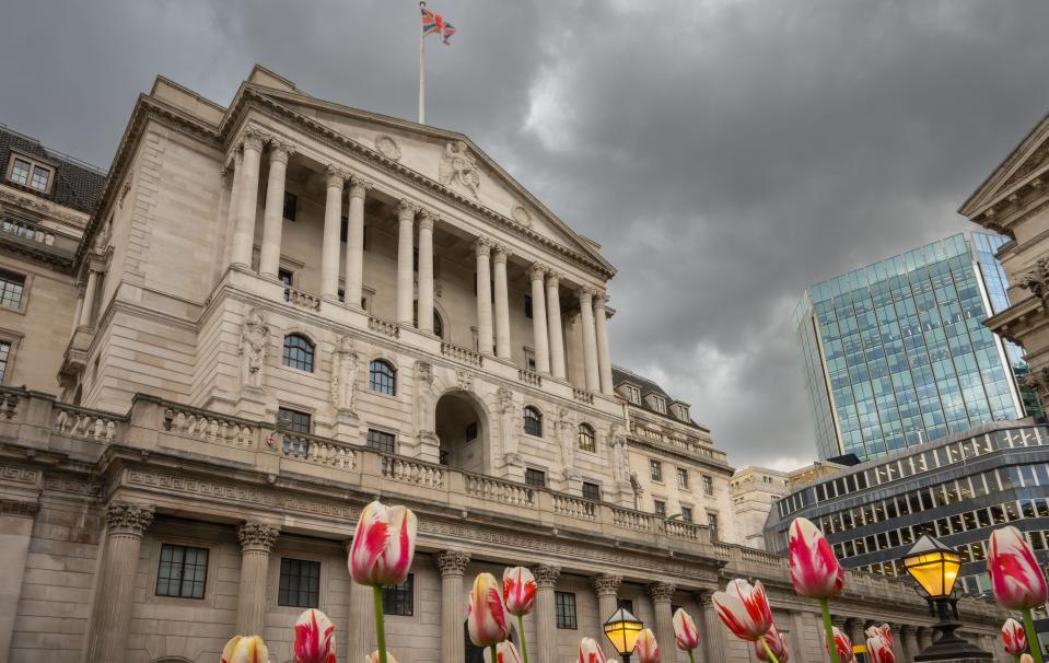 Londres, Reino Unido: Edificio del Banco de Inglaterra en la ciudad de Londres con tulipanes en primer plano.  Confianza empresarial en el Reino Unido