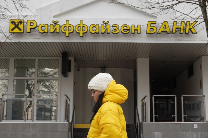 Una mujer camina frente a una sucursal del banco Raiffeisen en Moscú