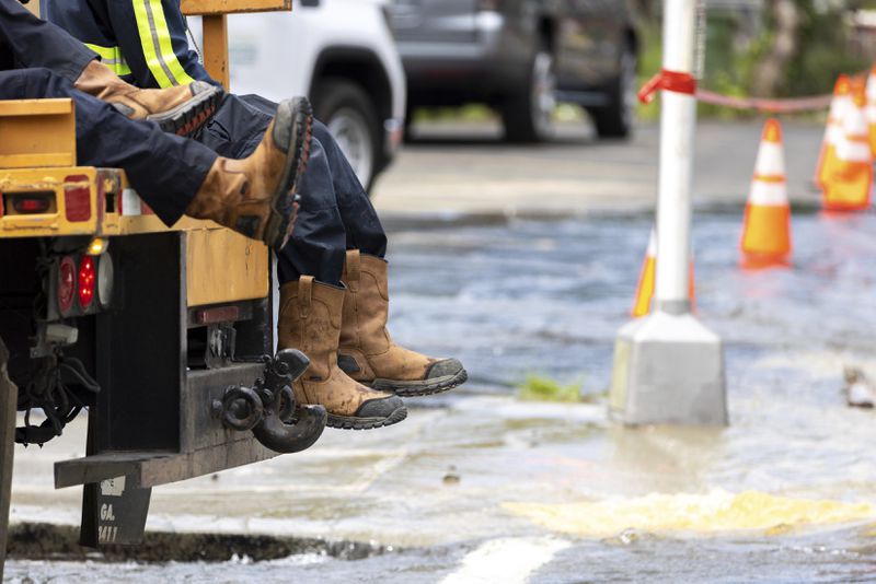 Los trabajadores llegan a una rotura de una tubería principal de agua en Joseph E. Boone Boulevard y James P. Brawley Drive en Atlanta, el viernes 31 de mayo de 2024. (Arvin Temkar/Atlanta Journal-Constitution vía AP)