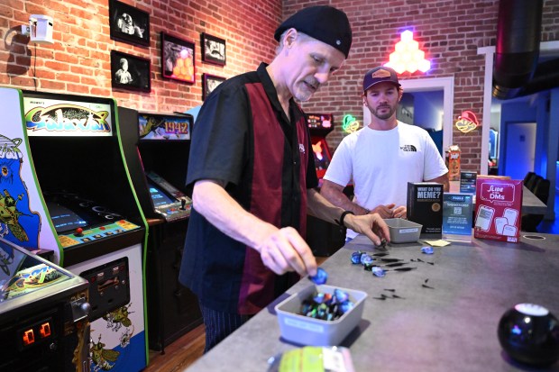 El propietario de Pixels Arcade Taproom, Rob Simmons, prepara dos juegos de dardos para Max Buchholz y su esposa en Pixels Arcade Taproom en San Rafael, California, el viernes 1 de junio de 2024. (Sherry LaVars/Marin Independent Journal)