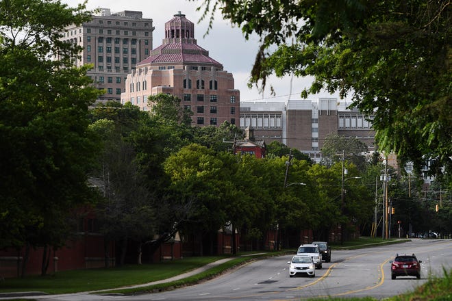 Los automovilistas viajan por Charlotte Street en Asheville, cerca del palacio de justicia del condado de Buncombe, a la izquierda, y del ayuntamiento, en el centro, el 4 de junio de 2024.