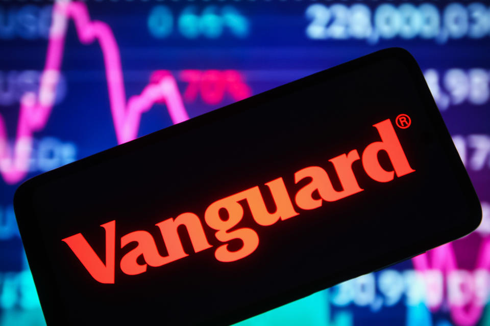 UCRANIA - 30/12/2021: En esta ilustración fotográfica, se ve el logotipo de Vanguard Group Inc. en la pantalla de un teléfono inteligente y un gráfico de líneas del mercado de valores en el fondo.  (Ilustración fotográfica de Pavlo Gonchar/SOPA Images/LightRocket vía Getty Images)