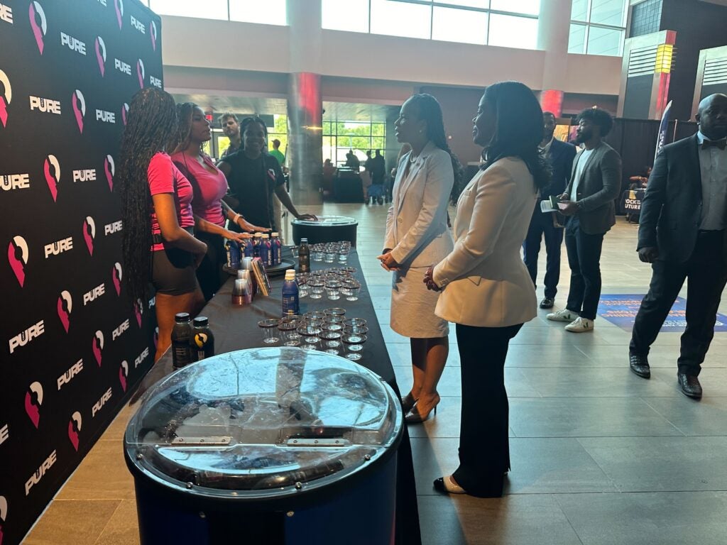 La representante Lisa Blunt y Regina Hairston, presidenta y directora ejecutiva de la Cámara de Comercio Afroamericana de Pensilvania, Nueva Jersey y Delaware, visitan un stand en la Black Business Expo en Filadelfia