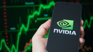 El logotipo de Nvidia Corporation se muestra en un teléfono inteligente con un gráfico del mercado de valores de fondo. Nvidia es un líder mundial en hardware de inteligencia artificial. Acciones de NVDA