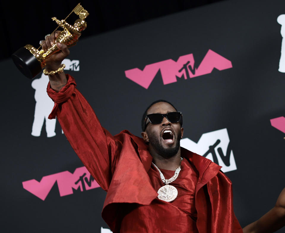 Diddy levanta su premio Ícono Global en los MTV Video Music Awards de 2023.