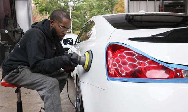 Jevaughn Evans pule un vehículo en Top Notch Auto Service, una empresa de detallado de automóviles y tintado de ventanas en East Bridgewater, el jueves 19 de septiembre de 2024.