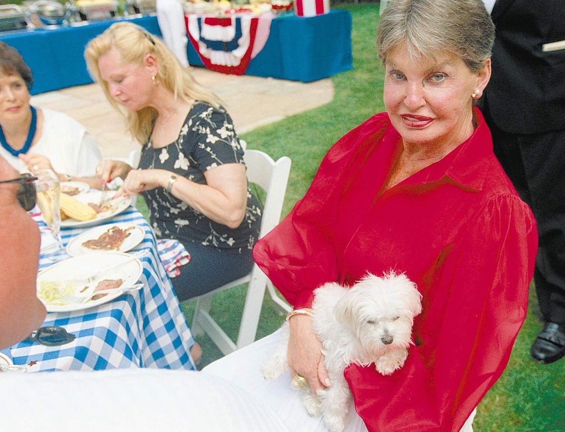 Leona Helmsley, a la derecha, aparece en esta foto del 4 de julio de 2000 con su perro Trouble durante la celebración de su 80º cumpleaños en su propiedad en Greenwich, Connecticut.