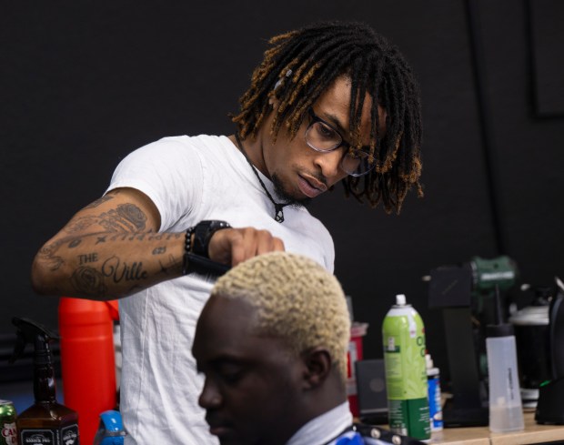 El barbero Trey Johnson limpia el cabello de Kendrick Koffi en Cold Cutz Lounge en la trastienda de la antigua barbería Ultimate Look, ahora conocida como Powder Room, donde alquila una silla, en St. Paul el jueves 3 de octubre de 2024. (John Autey/Prensa pionera)