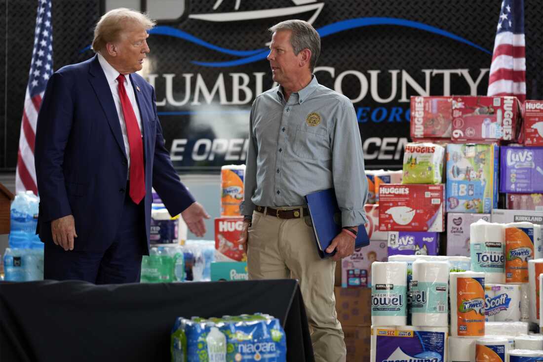 El expresidente Donald Trump habla con el gobernador de Georgia, Brian Kemp, después de hablar en un refugio de ayuda temporal en Evans, Georgia, una zona afectada por el huracán Helene.