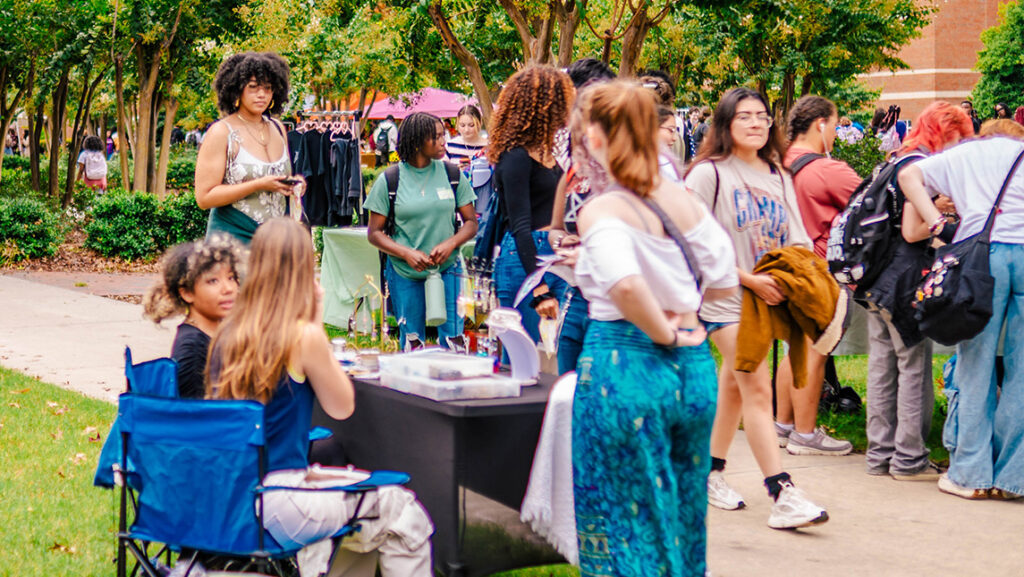 Los estudiantes deambulan por el mercado estudiantil de la UNCG afuera en College Avenue.