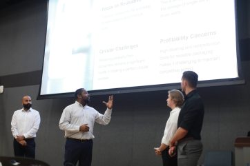 De izquierda a derecha: Sudhanshu Sarin, Dwayne Clarke, Cole Hudak y Jeremy Sanchez comparten su presentación ganadora con los jueces y miembros de la audiencia durante la competencia de casos de la Facultad de Negocios. Foto de Karen Pearlman.