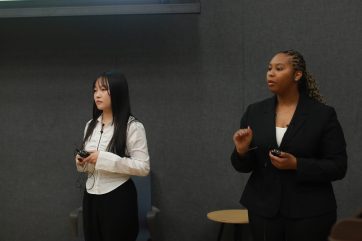 Mia Fischl y Alanah Cleare, estudiantes de negocios de la UMW, responden las preguntas de los jueces durante el concurso de casos de la Facultad de Negocios de otoño de 2024. Foto de Karen Pearlman.