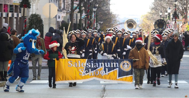 La mascota de los Delaware Blue Coats, Coaty, marcha en Market Street mientras la banda Salesianum la sigue durante el 57.º Desfile Anual de Navidad de Wilmington Jaycees el sábado 27 de noviembre de 2021.