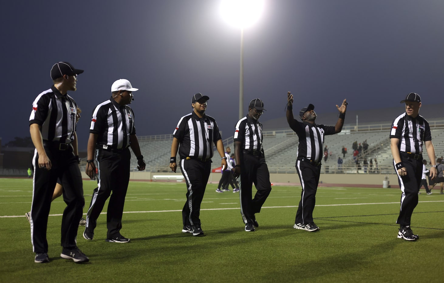 Los oficiales del juego abandonan el campo después de autorizar a los equipos de fútbol americano Richardson e Irving MacArthur...