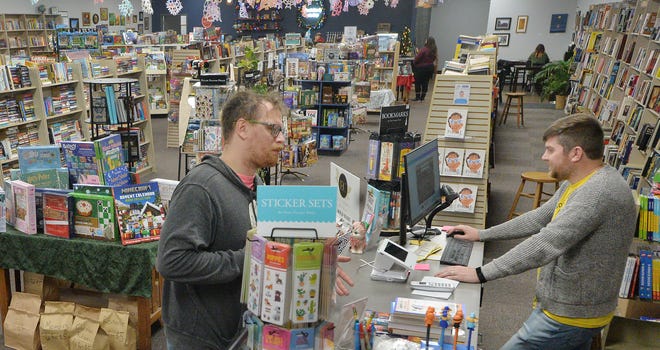 Francis Notoro, cliente de Werner Books & Coffee (izquierda), habla con el propietario Kyle Churman en la tienda Liberty Plaza en Erie el miércoles. Churman, de 36 años, está lidiando con la pérdida de negocios debido a una devastadora tormenta de nieve que cerró la mayoría de las carreteras en Small Business el sábado 29 de noviembre. Notoro, de 37 años, dijo que pasa por la tienda casi todos los días.