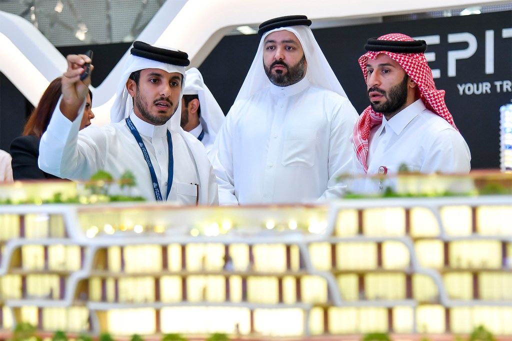 Tres personas en Qatar discutiendo sobre la compra de una propiedad.