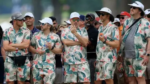 Getty Images Los fanáticos vestidos con camisetas y pantalones cortos hawaianos a juego ven la acción durante la segunda ronda del Campeonato de la PGA 2022 en Southern Hills Country Club el 20 de mayo de 2022 en Tulsa, Oklahoma.