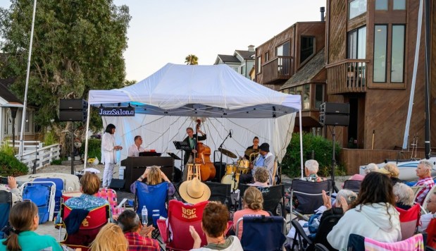 El propietario de Jazz Salon, David Ross, compró un piso de alfombra de goma y un paracaídas de carga para construir un escenario al aire libre para uno de sus espectáculos de jazz en Alamitos Bay, en Long Beach, California (Foto proporcionada por Jazz Salon).