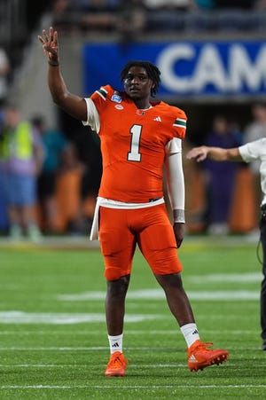 El mariscal de campo de Miami, Cam Ward, saluda a la multitud durante la segunda mitad del Pop Tarts Bowl contra Iowa State en el Camping World Stadium en Orlando, Florida. Jugó solo la primera mitad.